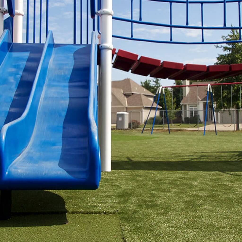 Blue slide on artificial grass installed by SYNLawn